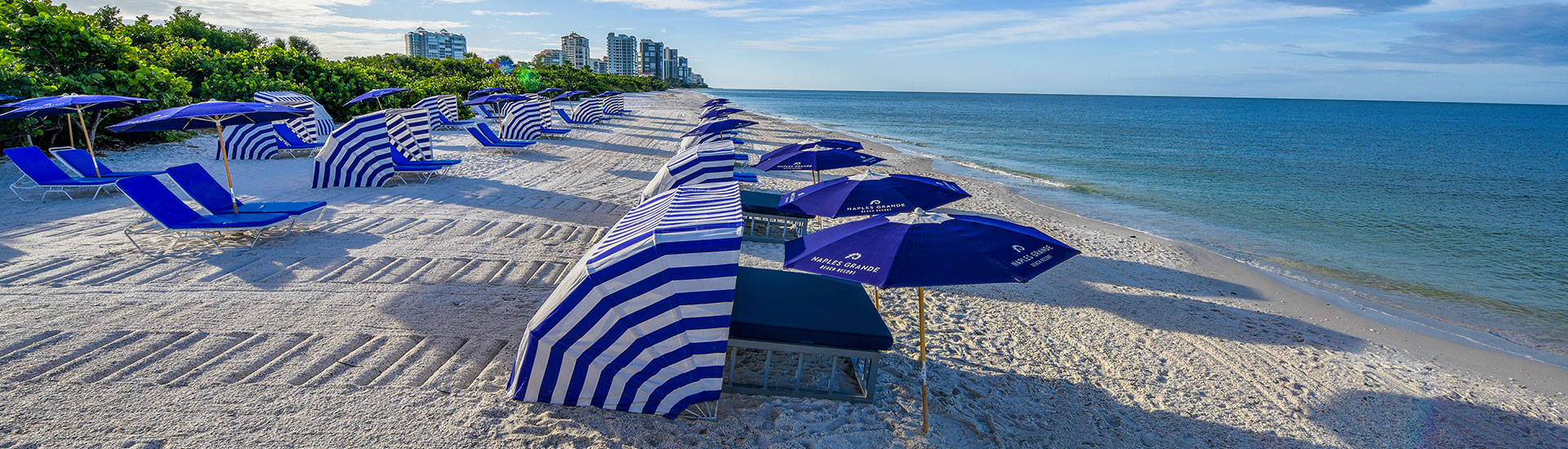 beach chairs and tables on naples grande beach